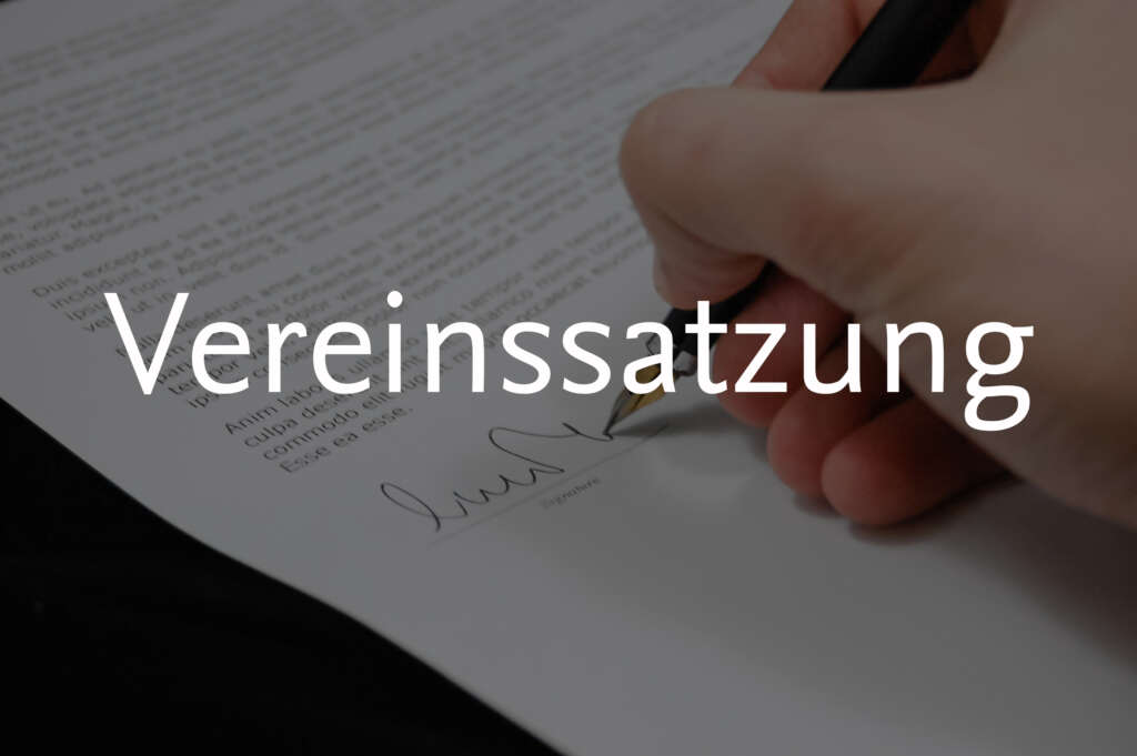 Eine Hand mit Füller unterschreibt ein Dokument, davor die Aufschrift "Vereinssatzung"